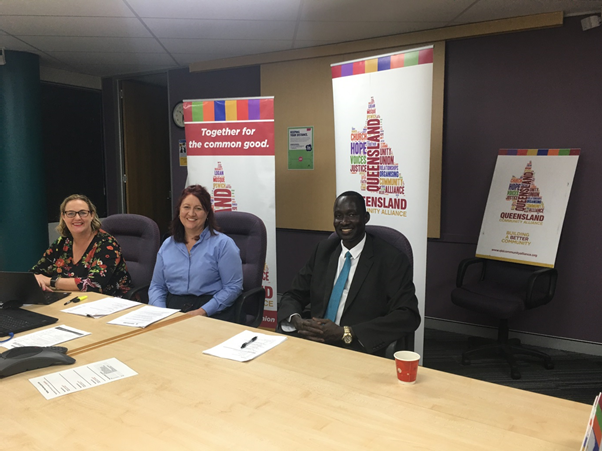 Beny Aterdit Bol sitting alongside two women at a meeting  