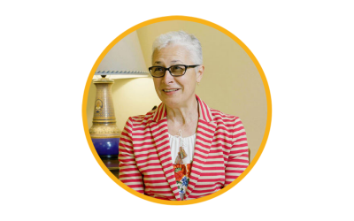 a portrait of a woman with short silver hair wearing a red jacket