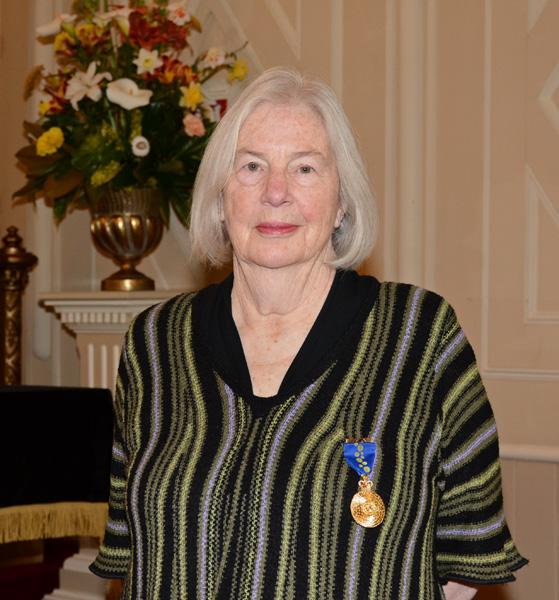Amanda Wojtowicz AM in black striped top, wearing her Order of Australia insignia