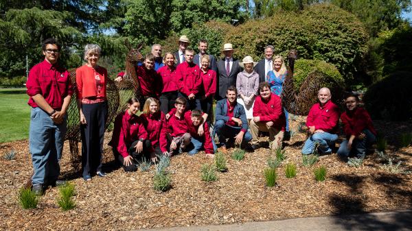 a group of people pose for a photo in a garden bed