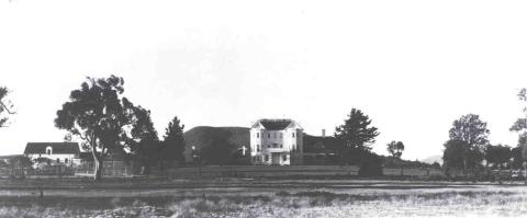 a black and white photograph showing a large building in the disance