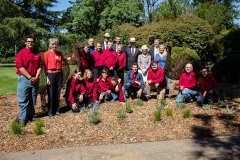 a group of people pose for a photo in a garden bed