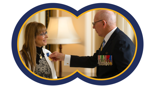 a man, on the right, presents a woman with a medal
