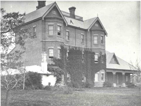 A black and white photograph of a three story house