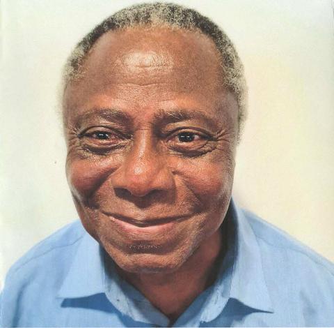 Ebenezer Banful OAM smiling at camera, wearing blue shirt