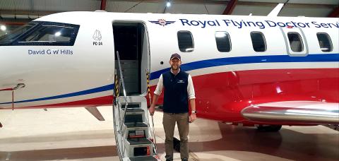 Dr Fergus Gardiner OAM standing near Royal Flying Doctor Service plane