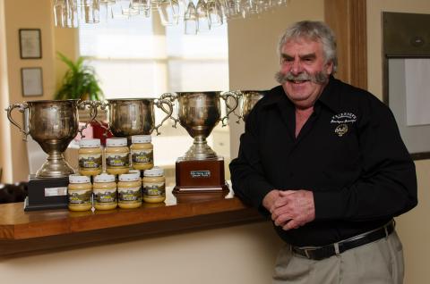 Headshot of Lindsay Bourke and trophies from beekeeping sector